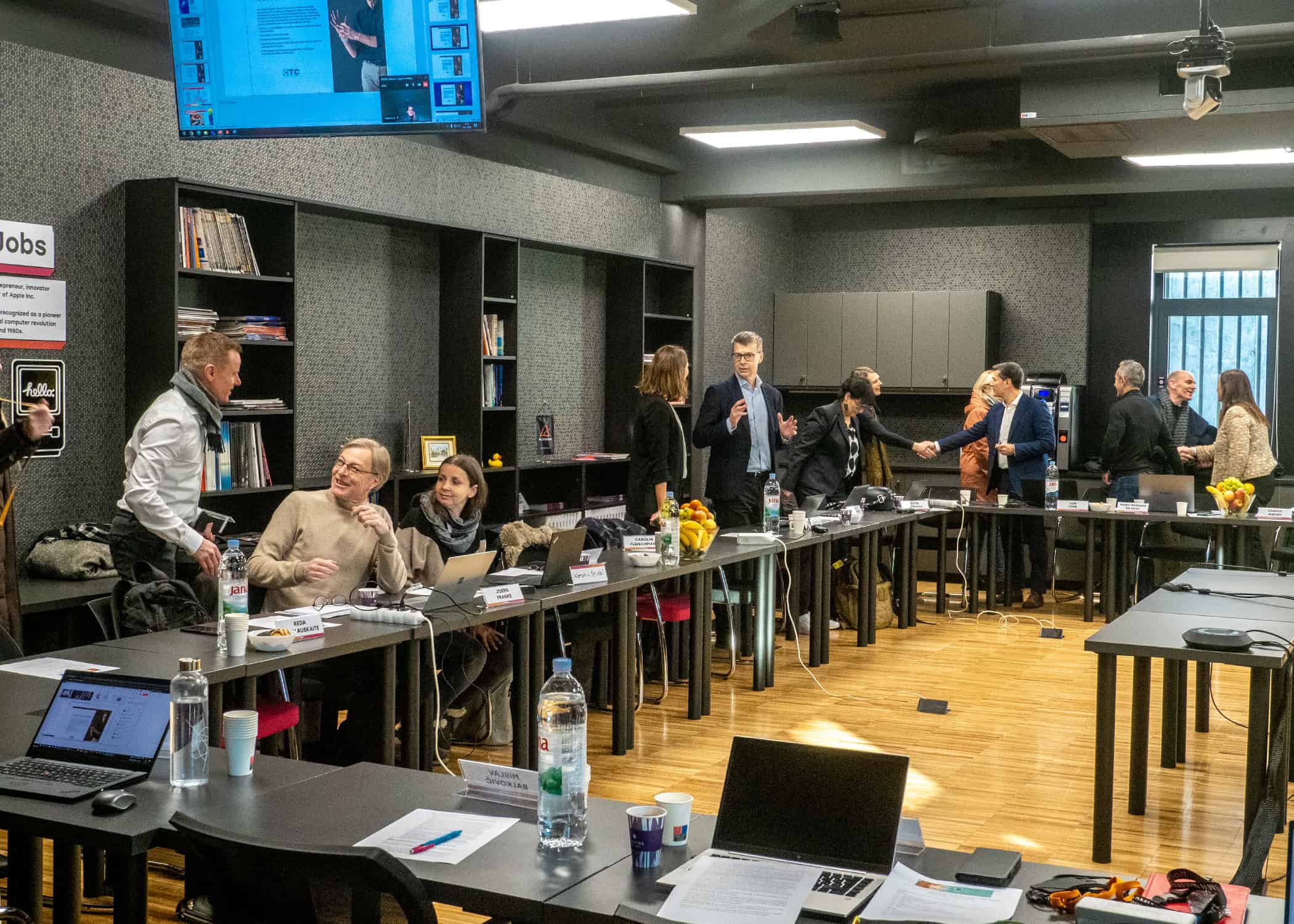 Diverse university conference room with professionals networking and engaging in discussions.