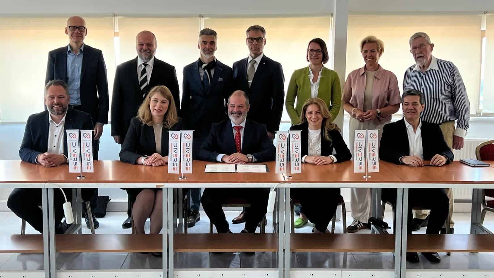 Diverse university team signing agreement for inclusive education at conference table.
