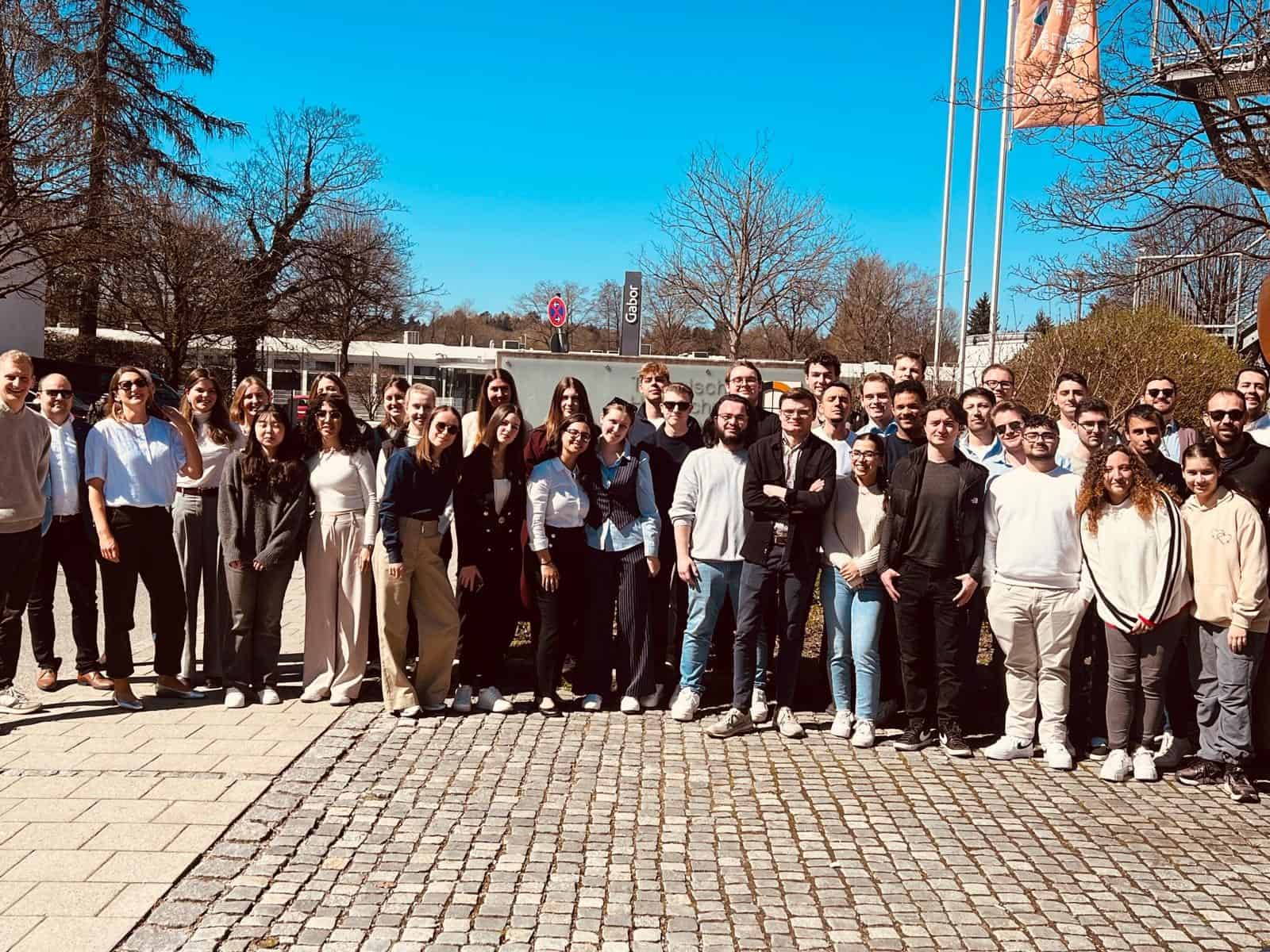 DIVERSE university group photo of students and faculty outdoors on a sunny day.