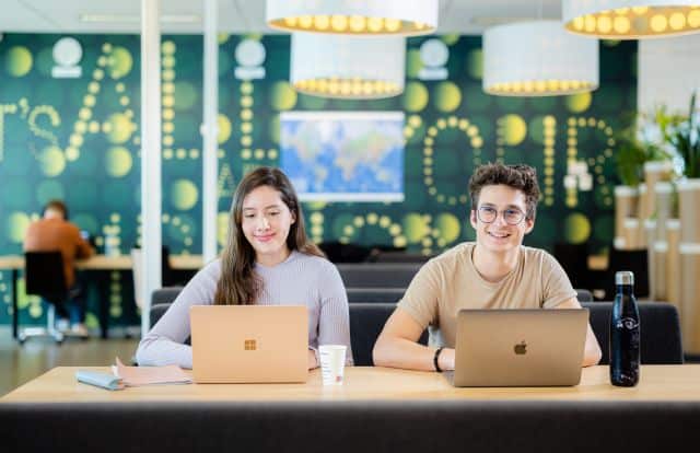 Diverse university students working together in a modern co-working space.