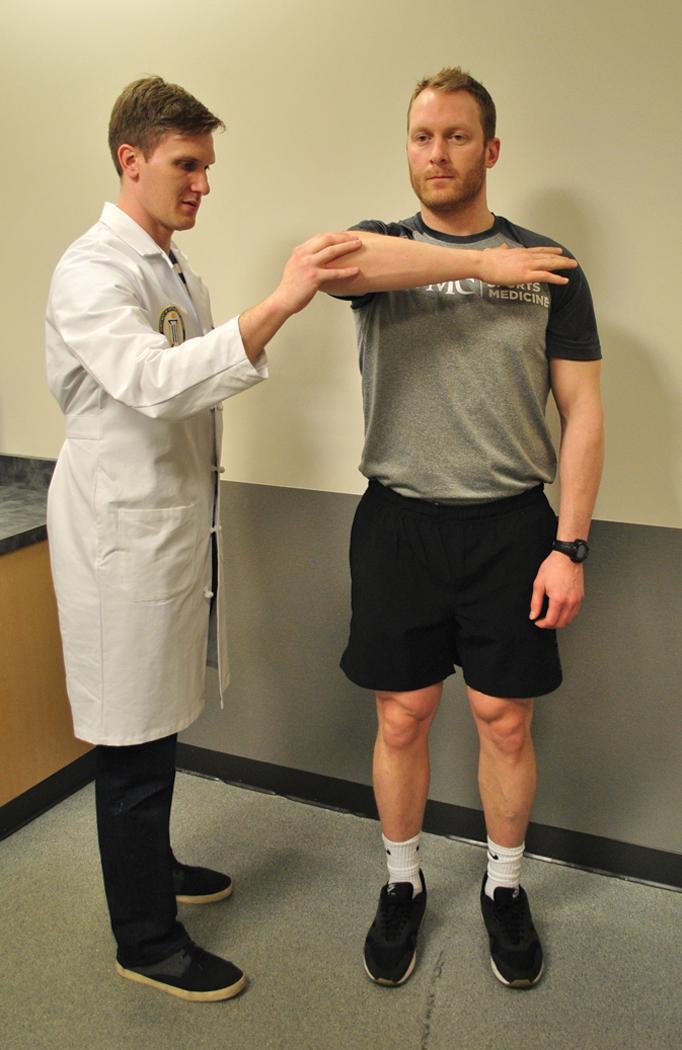 Fig. 9.6, The Whipple and modified Whipple tests involve the patient putting his or her hand on the contralateral shoulder and lifting the elbow toward the ceiling. Posterior shoulder pain indicates a positive test. The modification involves the examiner pushing with his or her thumb on the posterior humeral head, stabilizing it. Improvement in pain is typical.