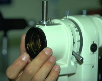 Fig. 11.1, A yellow barrier filter fitted to the front of the observation system of a slit lamp biomicroscope.