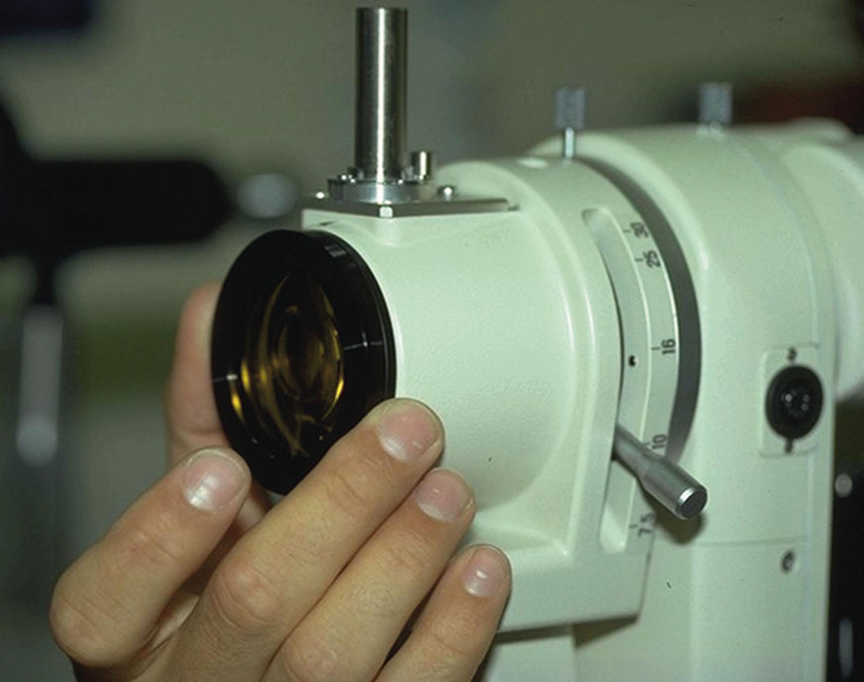 Fig. 34.15, Custom-designed barrier filter in position on the Nikon FS3 slit-lamp microscope. The slider for the zoom magnification system is also clearly seen.