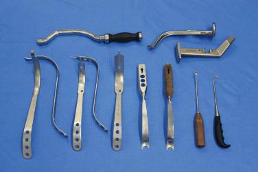 Fig. 14.1, Surgical instruments used in the described direct anterior approach: retractors, angled curette, bone hook, double-offset broaches and curved cup positioner.