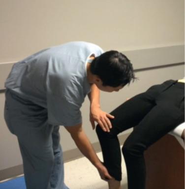 Fig. 80.5, The posterior impingement test is demonstrated. The patient is supine on the exam table, toward the end of the table with the hip resting in extension. The examiner externally rotates the hip, which will reproduce the pain if the symptoms are from posterior impingement.