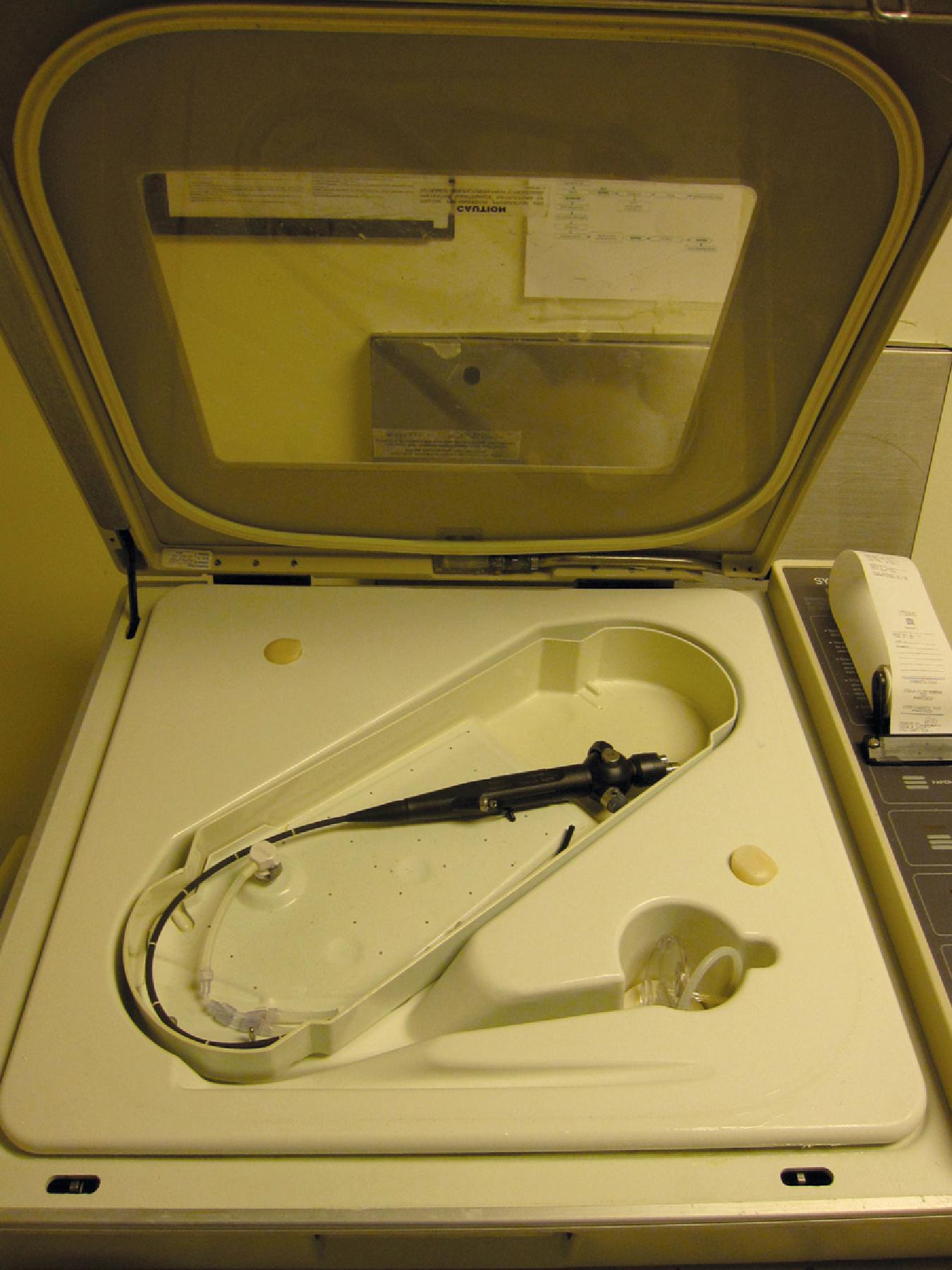 Fig. 24.5, Steris (Steris Corporation, Mentor, OH) machine for the sterilization of a flexible bronchoscope. The working channel is flushed out before being carefully placed within the sterilizer.