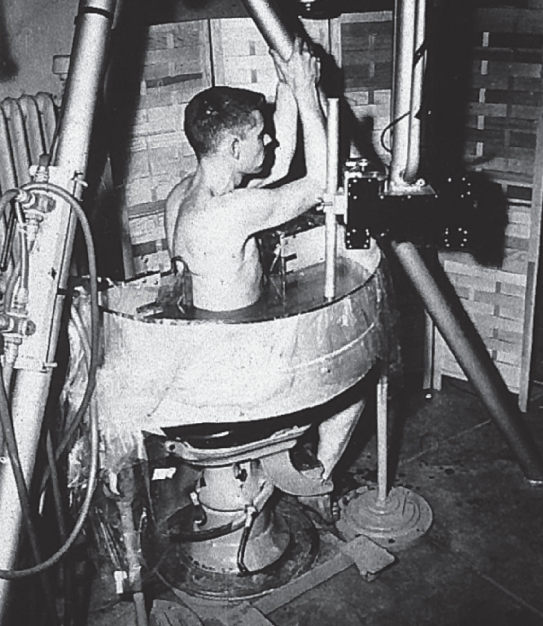 Fig. 1.3, The Pan Scanner , put together by the Holmes, Howry, Posakony, and Richard Cushman team in 1957, was a landmark invention in the history of B-mode ultrasonography. With the Pan Scanner, the patient sat on a modified dental chair strapped against a plastic window of a semicircular pan filled with saline solution while the transducer rotated through the solution in a semicircular arc.