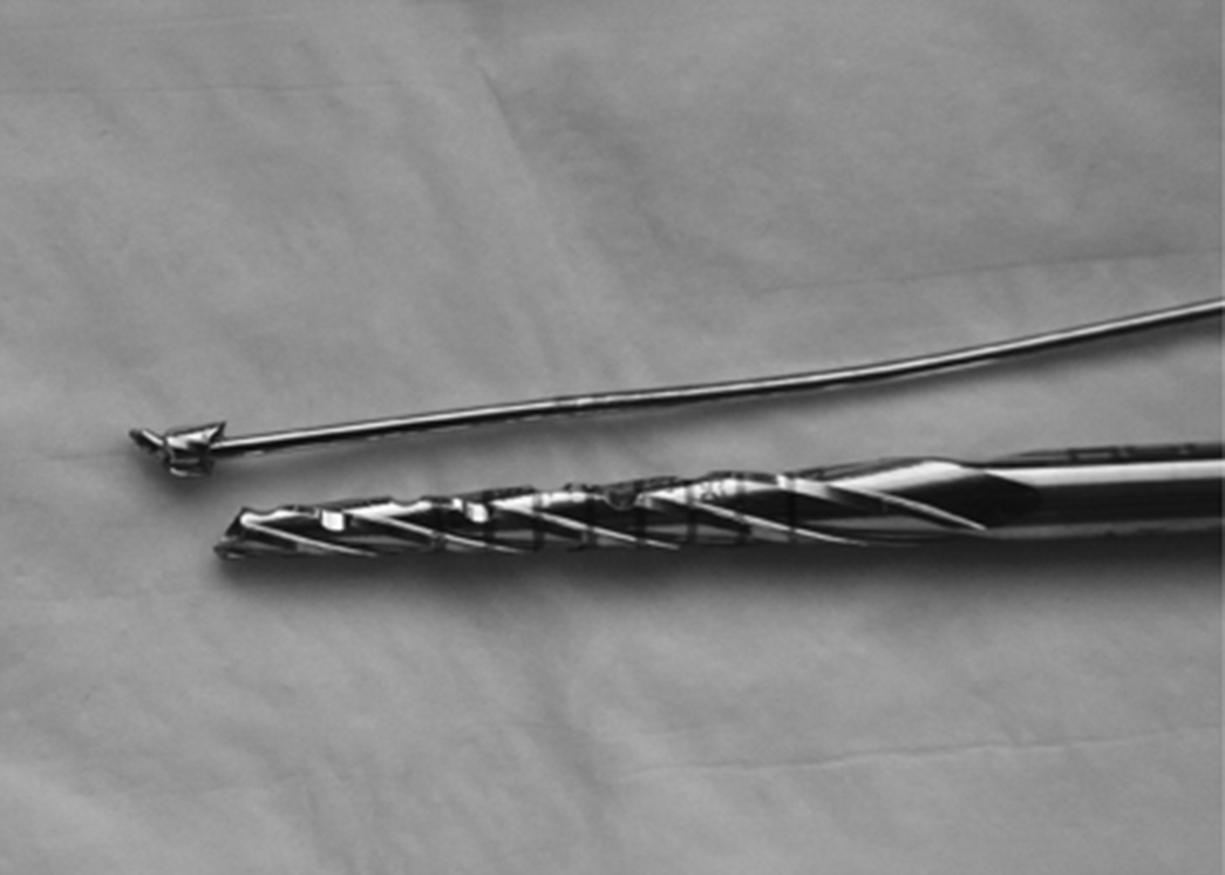 Fig. 16.15, Broken drill bit from attempting to drill over a bent guidewire.