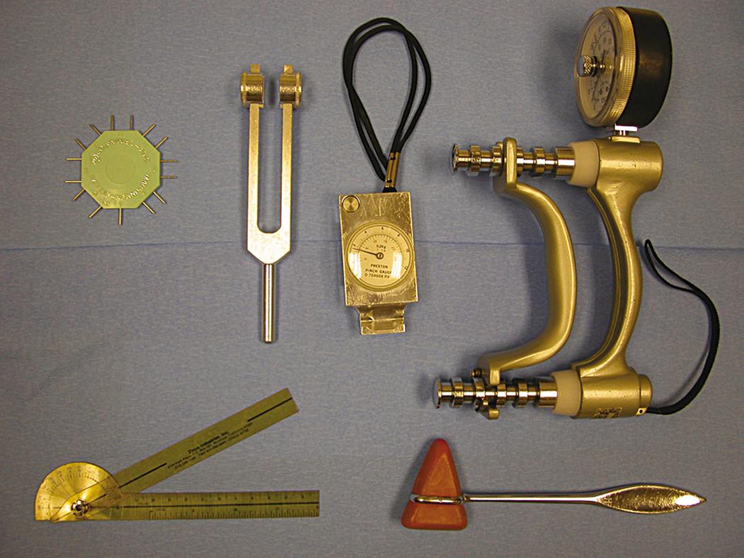 Fig. 70.6, Basic instruments used in hand examination include a tuning fork, pinch meter, grip dynamometer, two-point discriminator (paperclip also suffices), goniometer, and patella hammer.