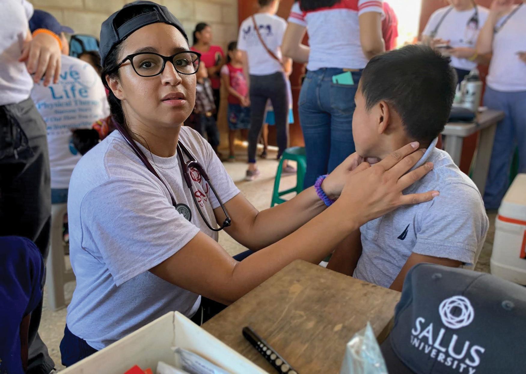 Fig. 34.1, Salus University physician assistant student Viviana DiStefano evaluates a young boy in Zacapa, Guatemala while participating in an international clinical experience.