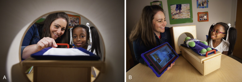 FIG 6-3, Play therapy and model MRI scanner. A child life specialist explains the MRI procedure to the child by ( A ) using a small-scale model MRI with a movable table and ( B ) employing a play-based approach using toys, showing pictures of the MRI and the body, and playing MRI sounds and videos on an electronic device.