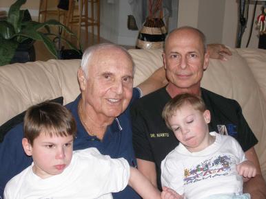 Figure 21.1, This image shows the author (JN), his father who is 27 years older, and his sons who are 4 and 6 years of age. The changes to the midface across this time continuum show how the volume of youth deflates and descends with age.