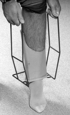 FIGURE 1, Applying a compression stocking with an adjunctive device.