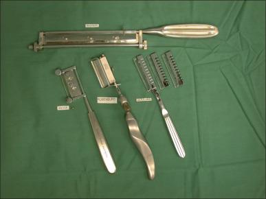 Fig. 12.3, A selection of hand-cutting dermatomes available for use for tangential excision. Most have the ability to set the aperture to the desired depth, while the Goulian has a large series of blade changeable guards.