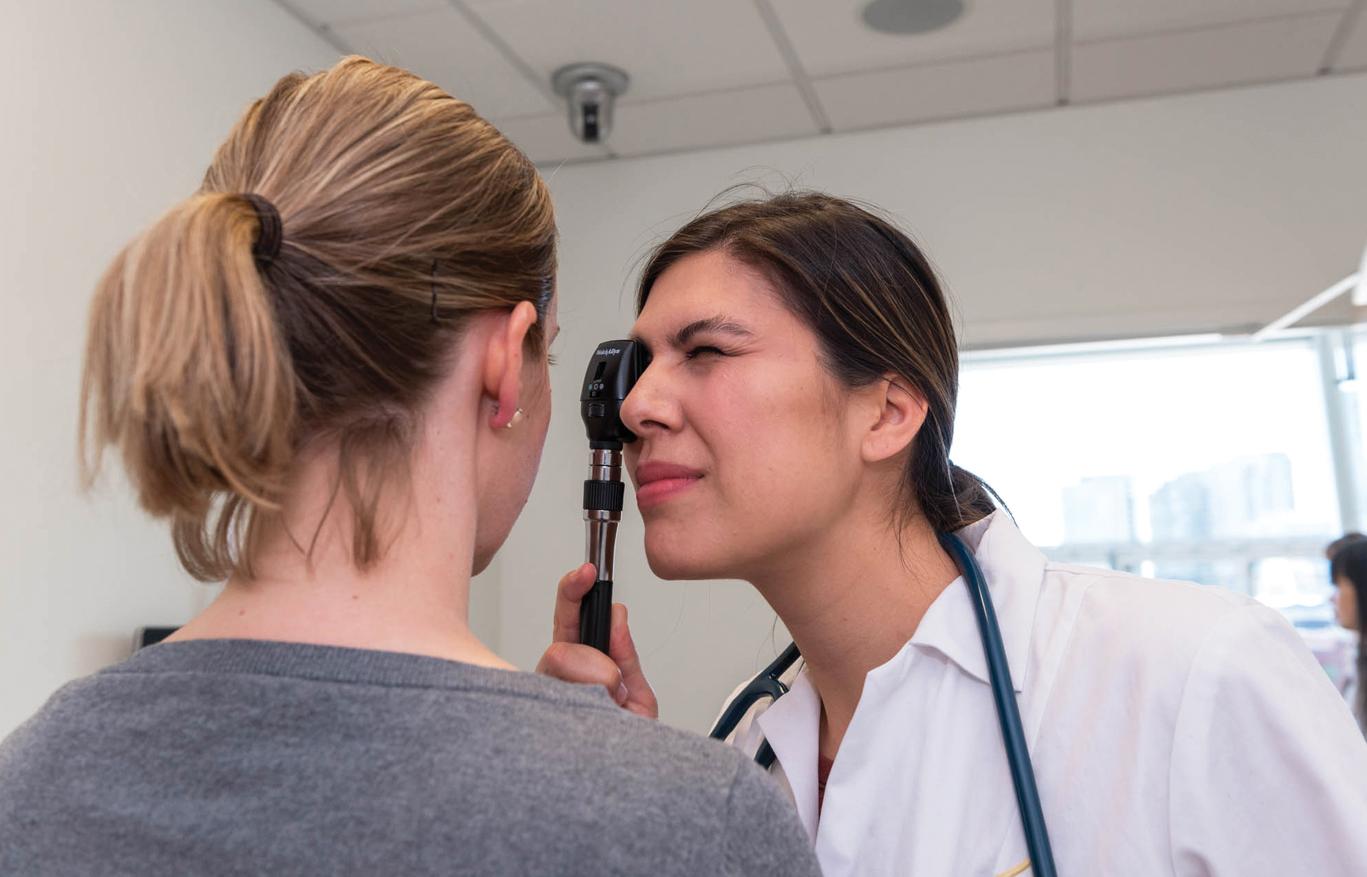 Fig. 32.1, Physician assistant student examining patient.