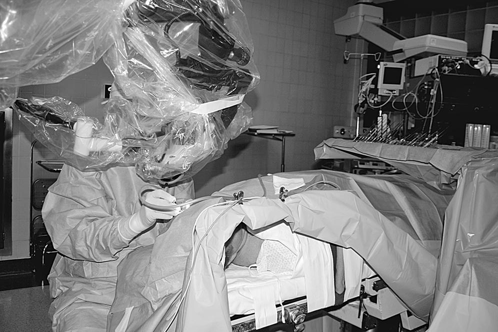 Fig. 1.12, A patient draped in the operating room for stapes surgery. Note the opening for the patient’s face opposite the surgeon.