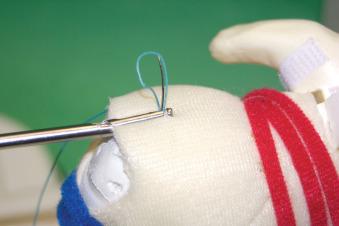 FIGURE 1.15, Needle advances suture through the tissue.