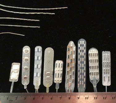 Figure 50.4, Since the 1970s (far left), spinal cord stimulation (SCS) paddle electrodes (bottom row) and supporting electronics have evolved from 2 to as many as 32 contacts, with up to 7 columns or centerlines, facilitating control of the midline by noninvasive programming. The first “transverse tripole” electrode (fourth from left) had a single full row of contacts, the longitudinal position of which was fixed at implantation; contemporary arrays have multiple rows as well as 3 or more columns. Percutaneous SCS electrodes have evolved from single contacts to as many as 16, facilitating longitudinal programming. They may be inserted in parallel to form multicolumn arrays.