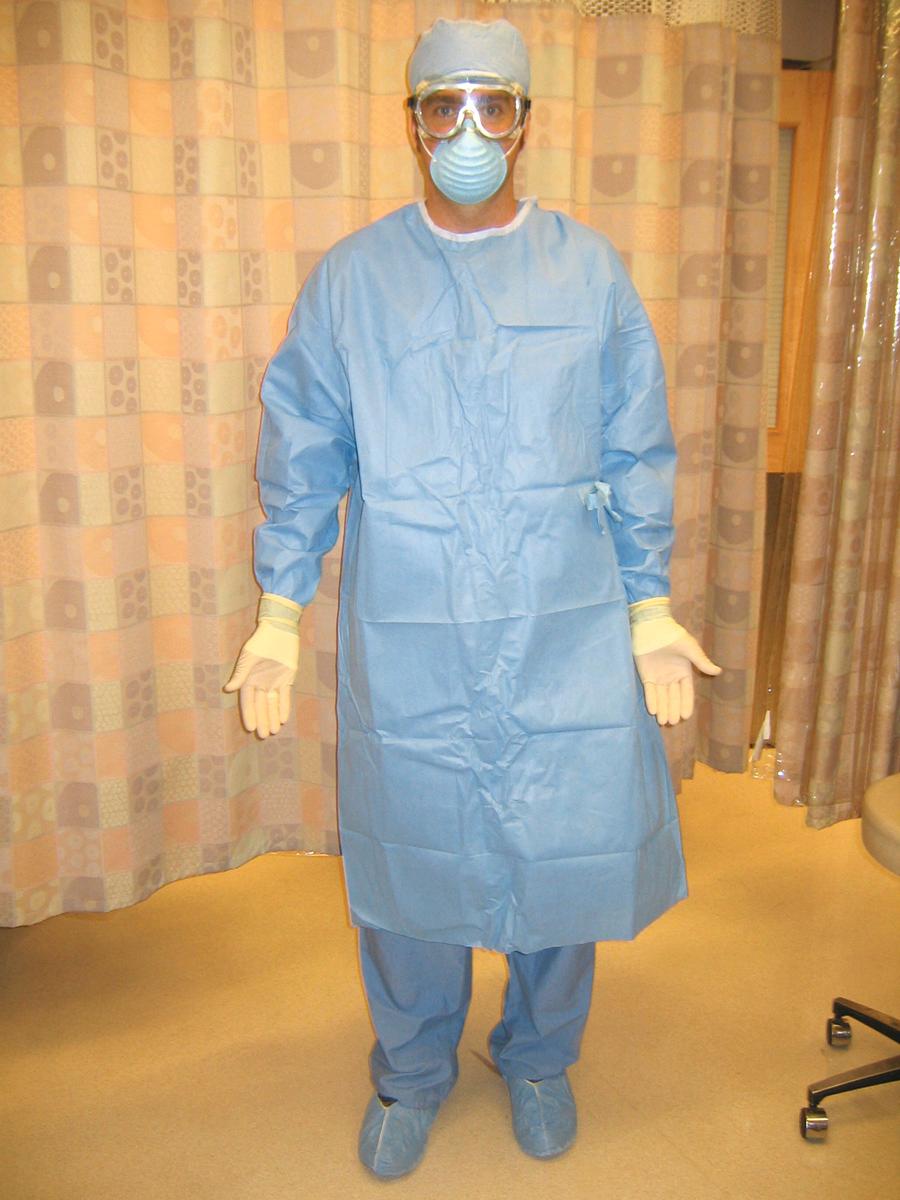 Figure 68.3, Full protective gear (eye protection, face mask, impervious gown, gloves, and shoe covers) should be worn when there is a risk for large volumes of splashed bodily fluids (e.g., emergency thoracotomy).