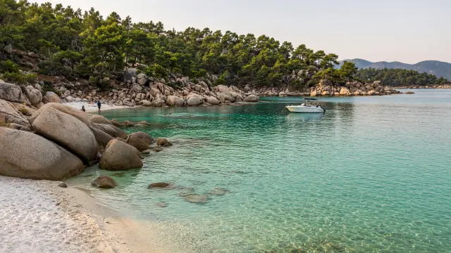 Kleine baai met wit zand, granieten rotsen en smaragdgroen water op Sithonia in Chalkidiki
