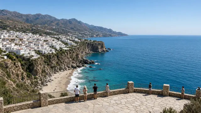 Uitkijkpunt op een klif boven kleine zandbaaien en een wit dorp in Nerja