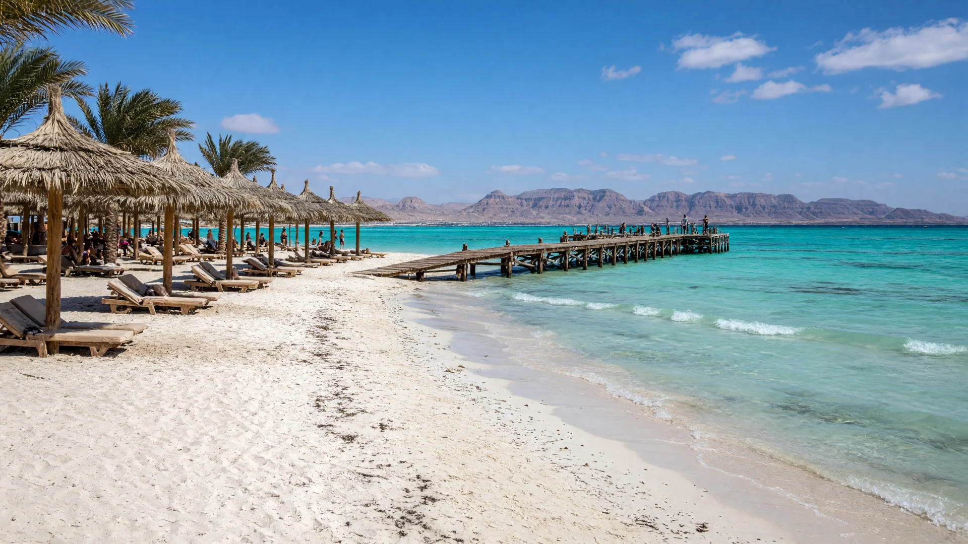Resortstrand met parasols en een houten steiger in Hurghada aan de Rode Zee