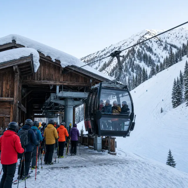 Besneeuwde pistes en skiliften boven het dorpscentrum van Flachau met bergtoppen op de achtergrond