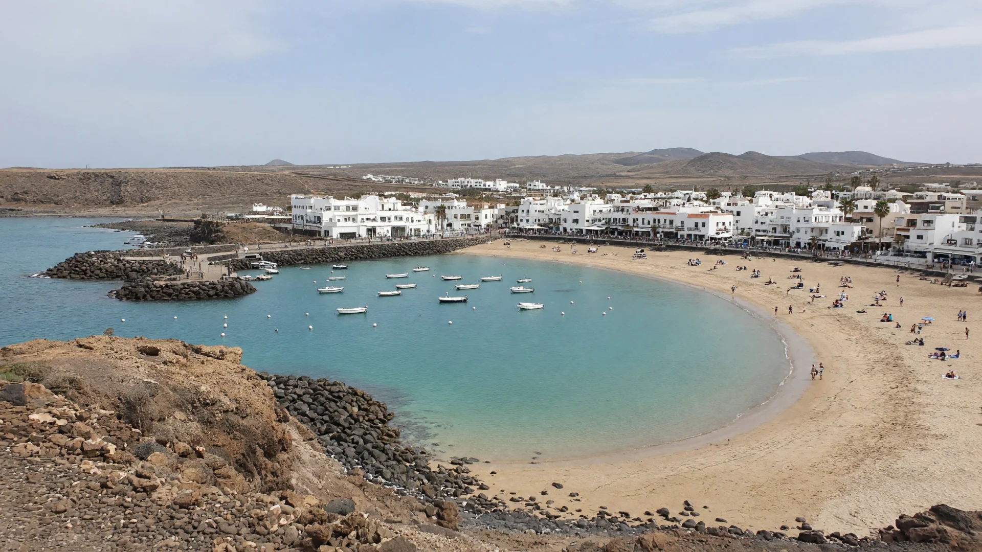 Beschutte baai met haventje en witte gebouwen in Caleta de Fuste