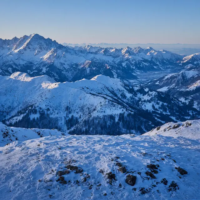 Skiërs bij een bergstation in Königsleiten met zicht op besneeuwde pistes en bergtoppen in Tirol