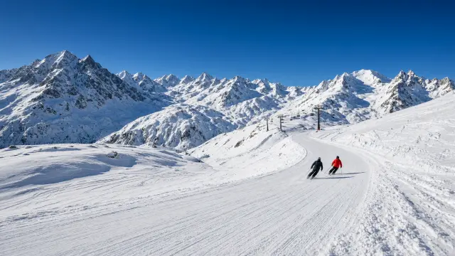 Skiërs op een gletsjerpiste in het hooggebergte in december