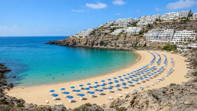 Halvemaanvormig strand met licht zand en turquoise water in Amadores op Gran Canaria