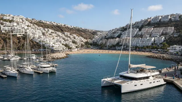 Jachthaven van Puerto Rico op Gran Canaria met zeilboten en witte appartementen op de steile hellingen