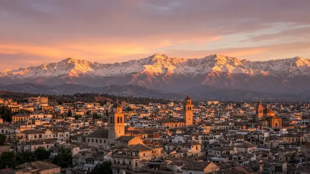 De daken van Granada bij zonsondergang met de Sierra Nevada in de verte