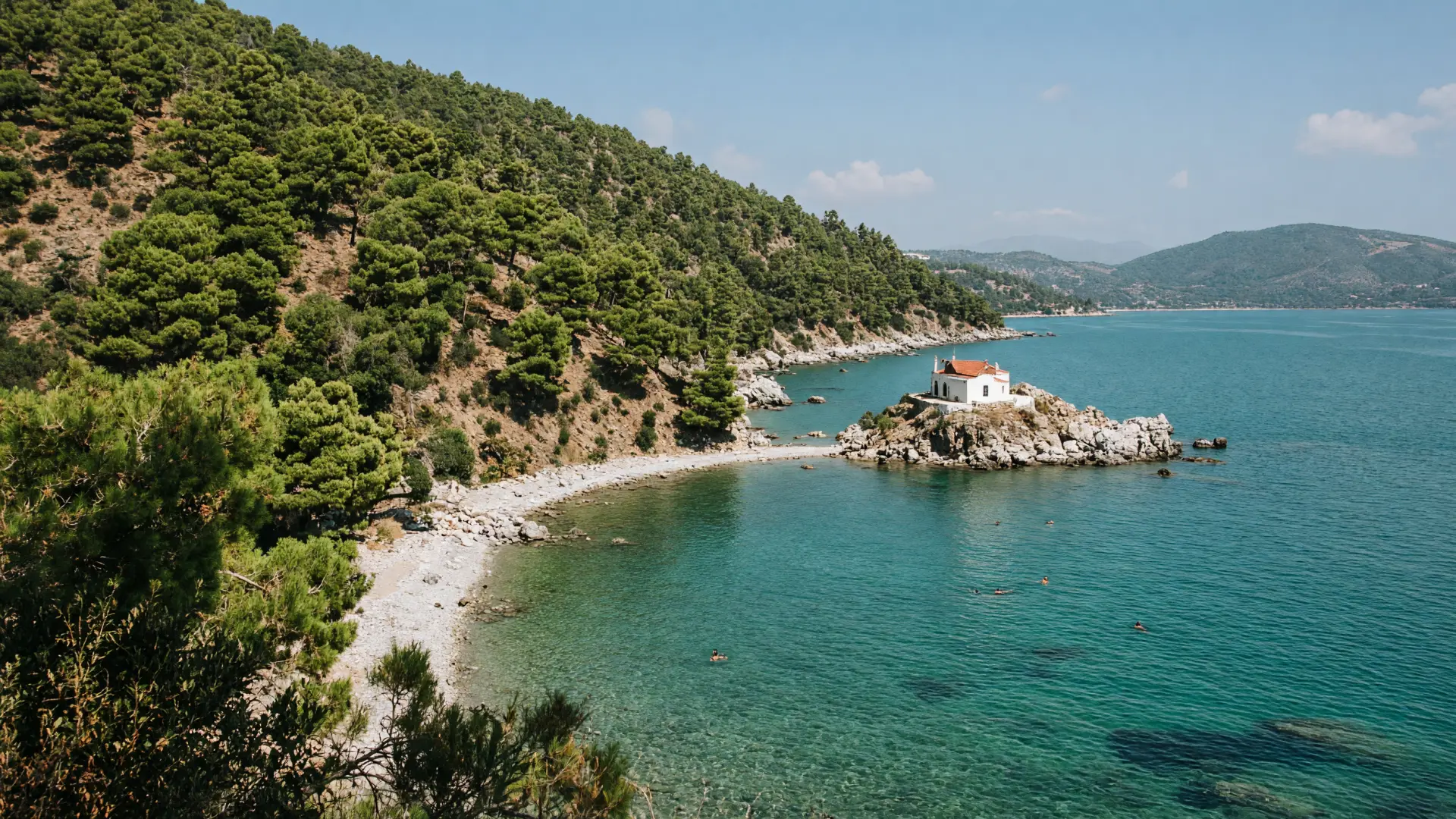 Groene baai met een kiezelstrand en een kapelletje op Samos