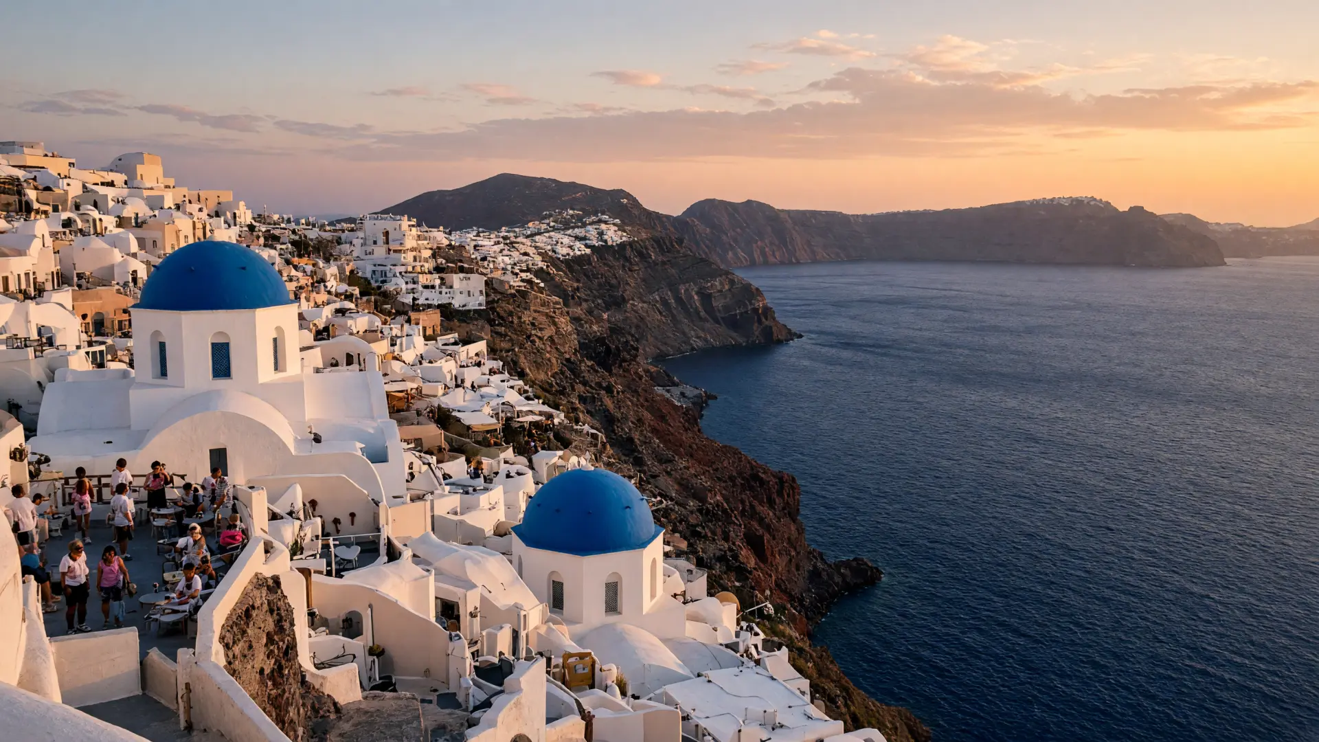Witte huizen en blauwe koepels op de kliffen van de caldera van Santorini
