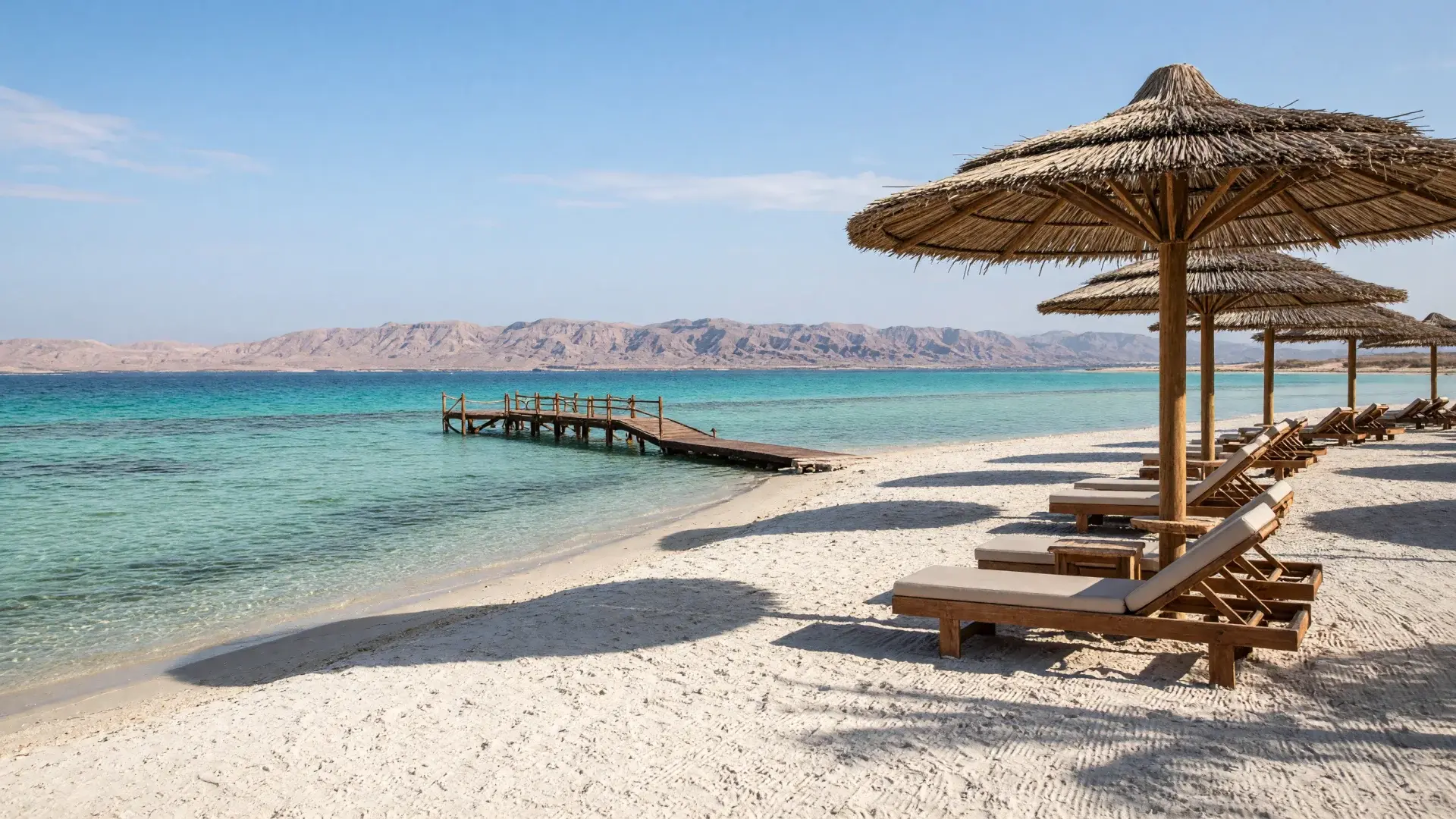 resortstrand met parasols en een steiger aan de Rode Zee in Hurghada