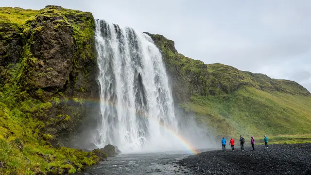 Wandelaars bij de waterval Skógafoss aan de zuidkust van IJsland