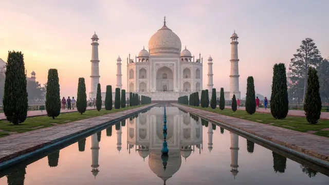De Taj Mahal in Agra bij zonsopgang, gezien vanuit de tuinen, met enkele reizigers langs de vijver