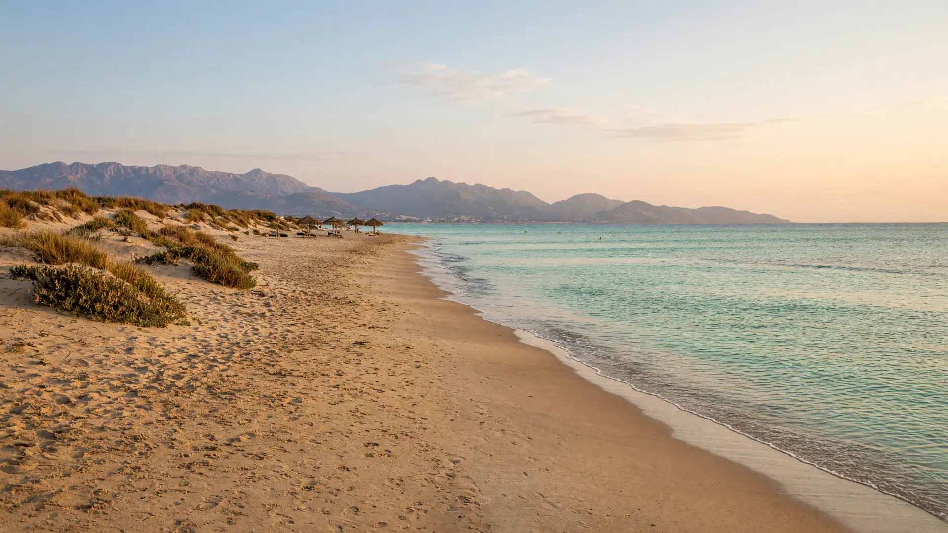 Lang zandstrand met lage duinen bij Malia op Kreta