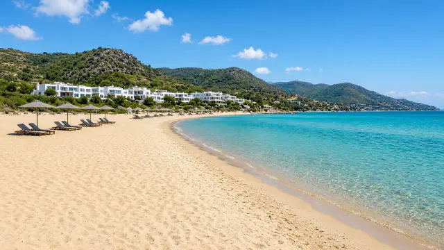 Breed zandstrand aan de noordkust van Kreta met ligbedden en parasols