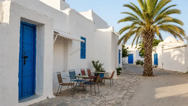Straatje met witte huizen en blauwe deuren in Houmt Souk op Djerba