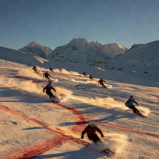 Snowboarders rijden door het snowpark in het centrale skigebied van Les 2 Alpes met freestyle obstakels en brede goed geprepareerde pistes
