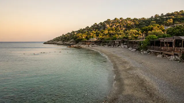 Rustige baai met zand en fijne kiezels en tavernes met houten terrassen in Anaxos op Lesbos
