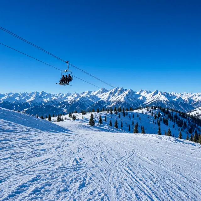 Breed panoramisch uitzicht over besneeuwde bergtoppen en uitgestrekte skipistes in het Italiaanse hooggebergte met moderne skiliften