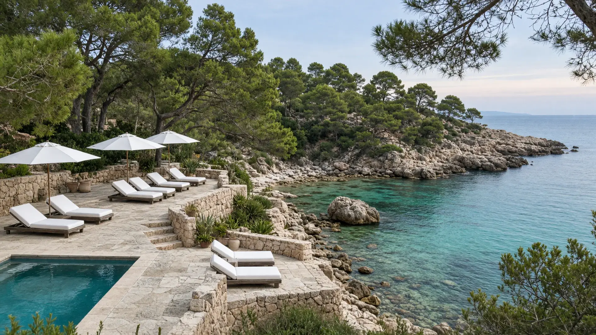 hotelterras met ligstoelen boven een rotsbaai op Mallorca