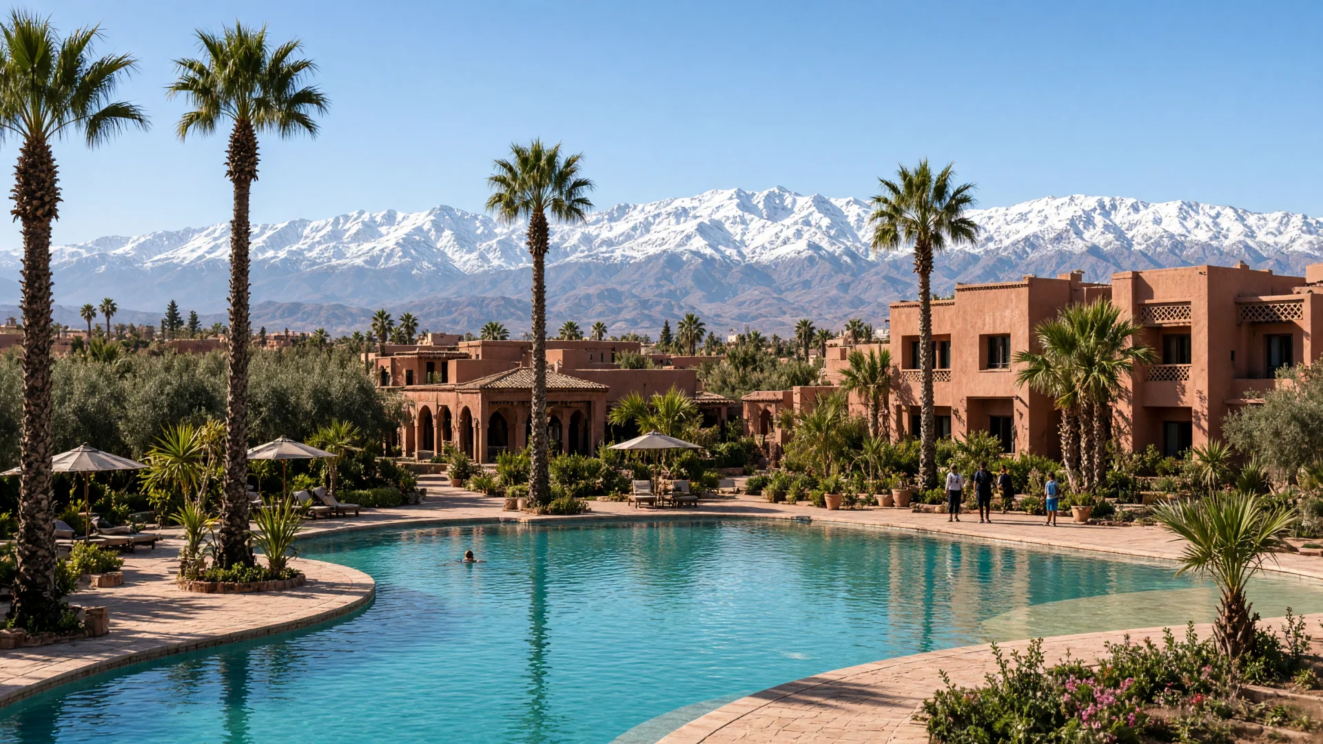 Resort met groot zwembad en palmbomen bij Marrakech, met het Atlasgebergte op de achtergrond
