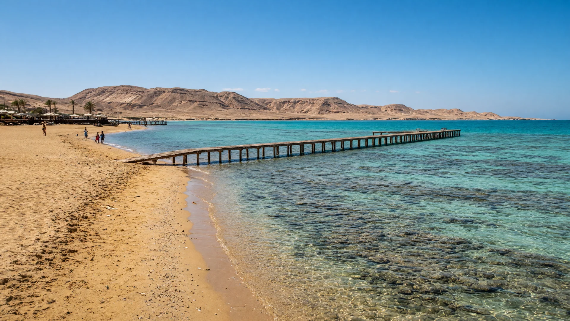 Turquoise lagune met een houten steiger aan de kust bij Marsa Alam