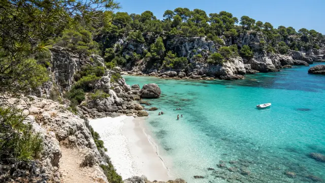 Kleine baai met wit zand en turquoise water aan de zuidkust van Menorca