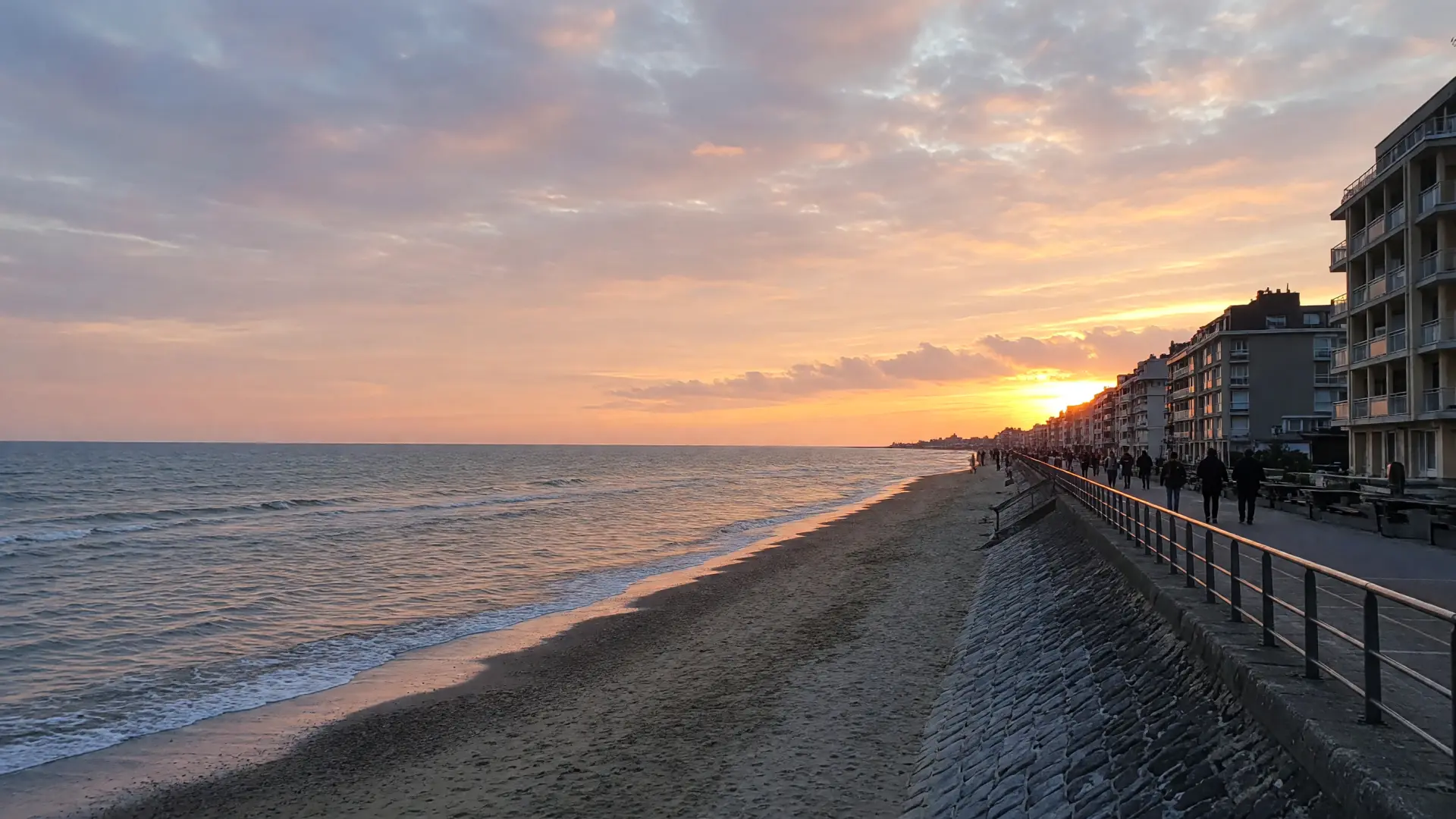 Zeedijk en strand bij zonsondergang aan de Belgische kust