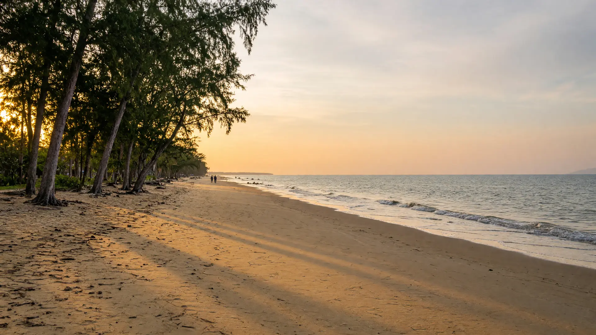 Een rustig lang strand bij Thalang in het noorden van Phuket bij zonsondergang